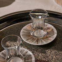 طقم تمرة بالتعاون مع رزان العزوني سترايبس المؤلف من فنجانين عربيين للشاي مع صحنيهما باللون الذهبي صلصال طقم تمرة بالتعاون مع رزان العزوني سترايبس المؤلف من فنجانين عربيين للشاي مع صحنيهما باللون الذهبي