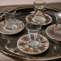 طقم تمرة بالتعاون مع رزان العزوني المؤلف من 6 فناجين عربية للشاي مع صحونها باللون الذهبي صلصال طقم تمرة بالتعاون مع رزان العزوني المؤلف من 6 فناجين عربية للشاي مع صحونها باللون الذهبي