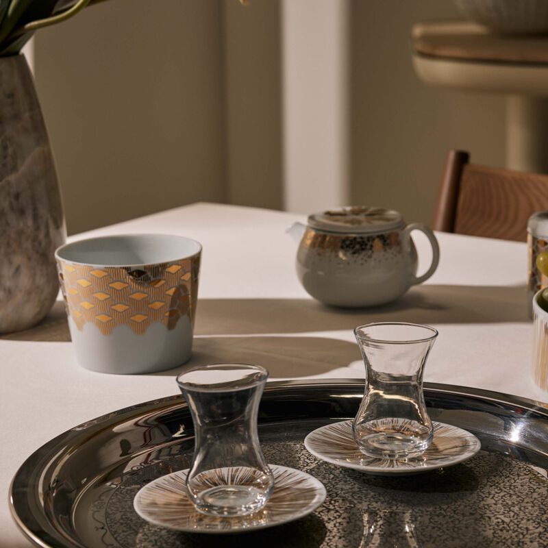 طقم تمرة بالتعاون مع رزان العزوني سترايبس المؤلف من فنجانين عربيين للشاي مع صحنيهما باللون الذهبي صلصال طقم تمرة بالتعاون مع رزان العزوني سترايبس المؤلف من فنجانين عربيين للشاي مع صحنيهما باللون الذهبي